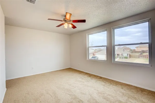 an empty room with windows and fan