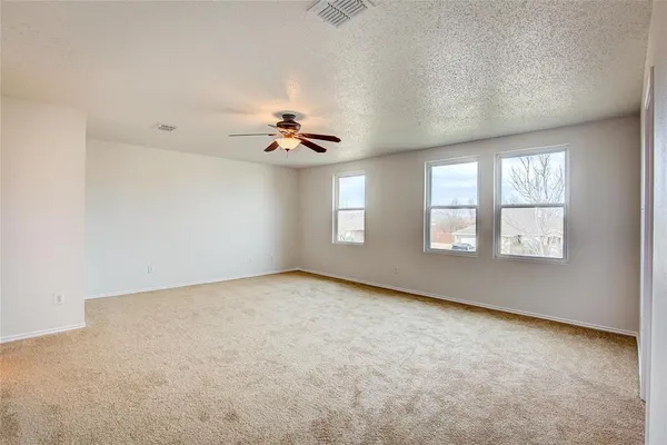 an empty room with windows and ceiling fan view