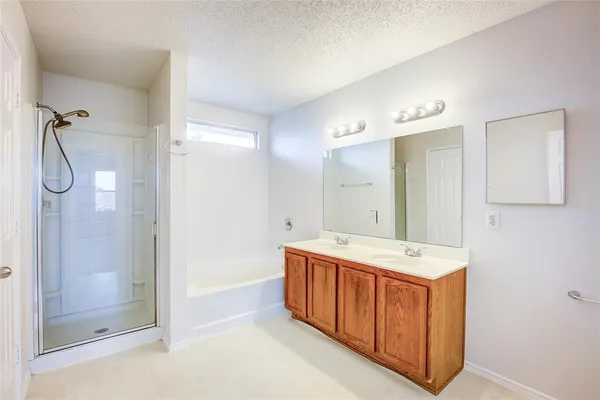 a spacious bathroom with a double vanity sink mirror and shower
