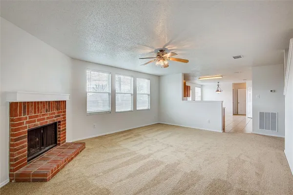 an empty room with windows and fireplace
