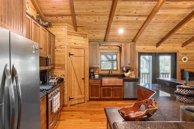 a kitchen with stainless steel appliances granite countertop a refrigerator a stove and a sink