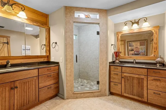 a bathroom with a granite countertop sink a mirror and a shower