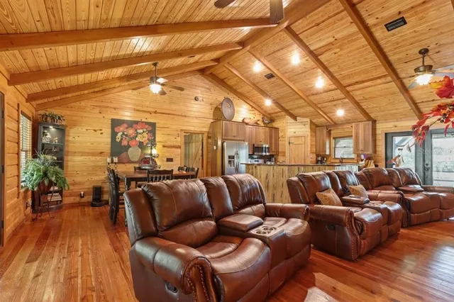 a media room with lots of chairs and wooden floor