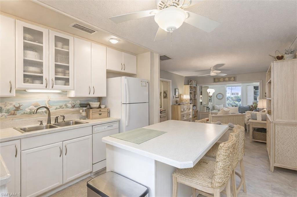 5 High Point Circle West, Unit 308 Naples, FL 34103 - Photo 12 of 28 a kitchen with kitchen island a sink stove and refrigerator