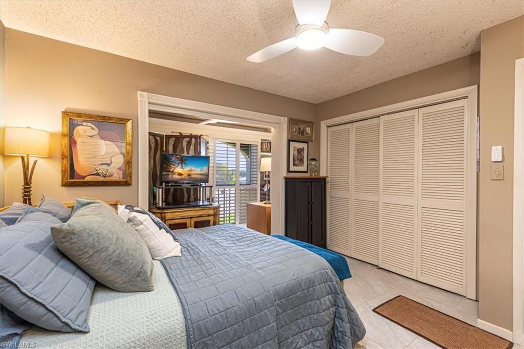 5 High Point Circle West, Unit 308 Naples, FL 34103 - Photo 14 of 28 a bed room with a bed and a chandelier