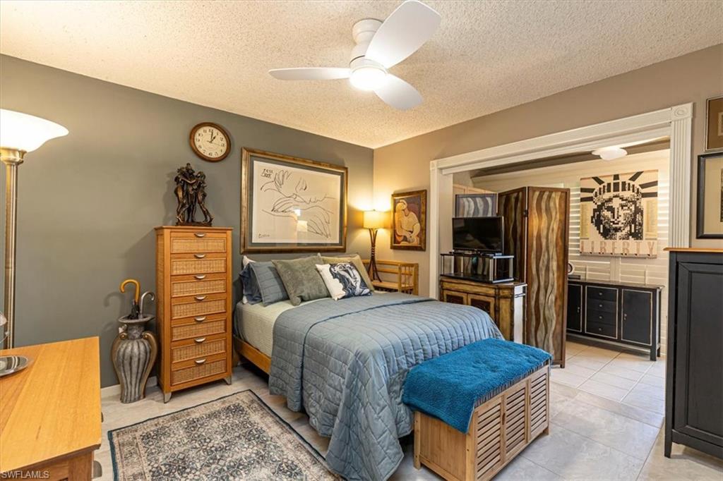 5 High Point Circle West, Unit 308 Naples, FL 34103 - Photo 18 of 28 a bedroom with a bed and a television