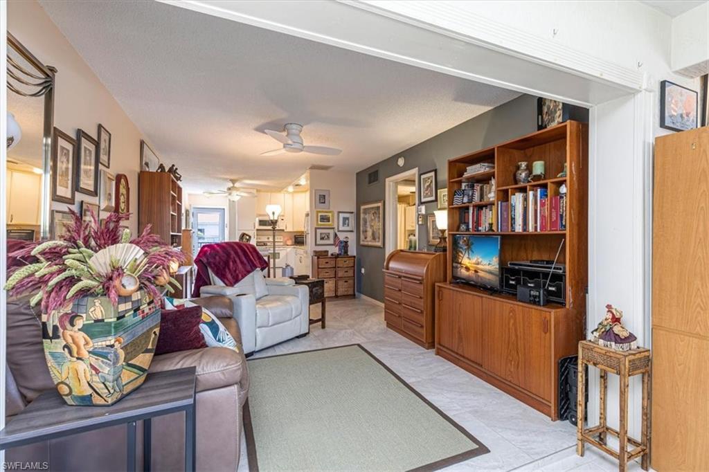5 High Point Circle West, Unit 308 Naples, FL 34103 - Photo 7 of 28 a living room with furniture and a flat screen tv