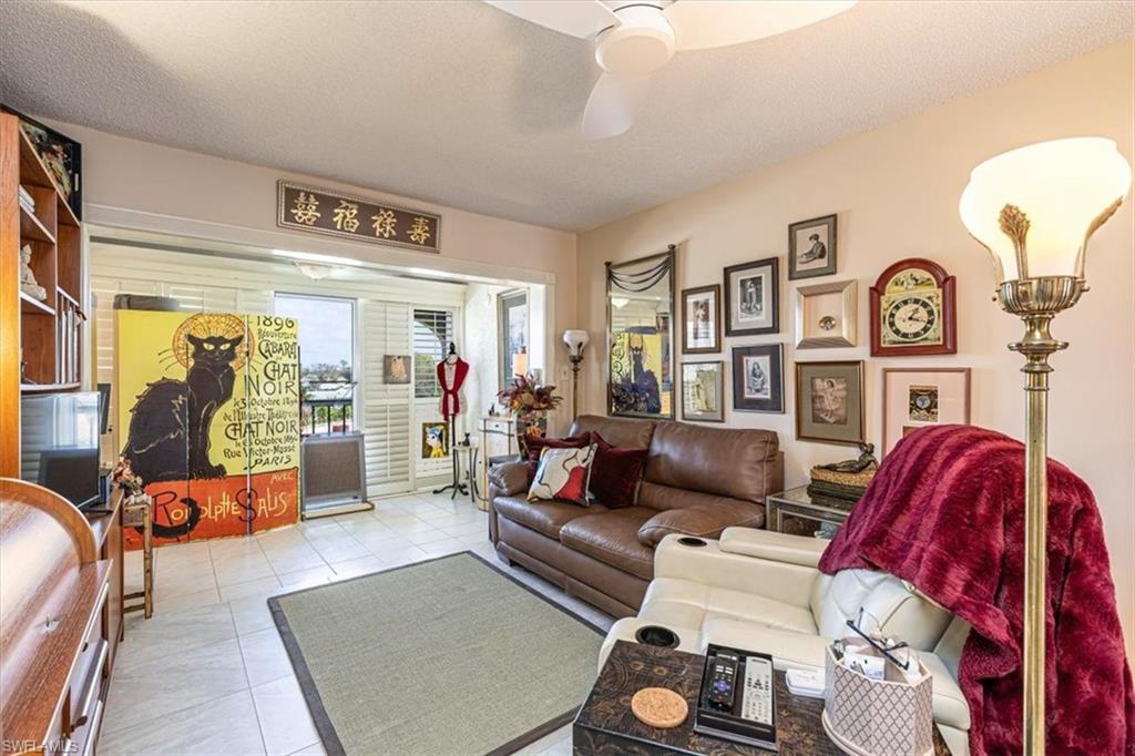 5 High Point Circle West, Unit 308 Naples, FL 34103 - Photo 8 of 28 a living room with furniture and a large window