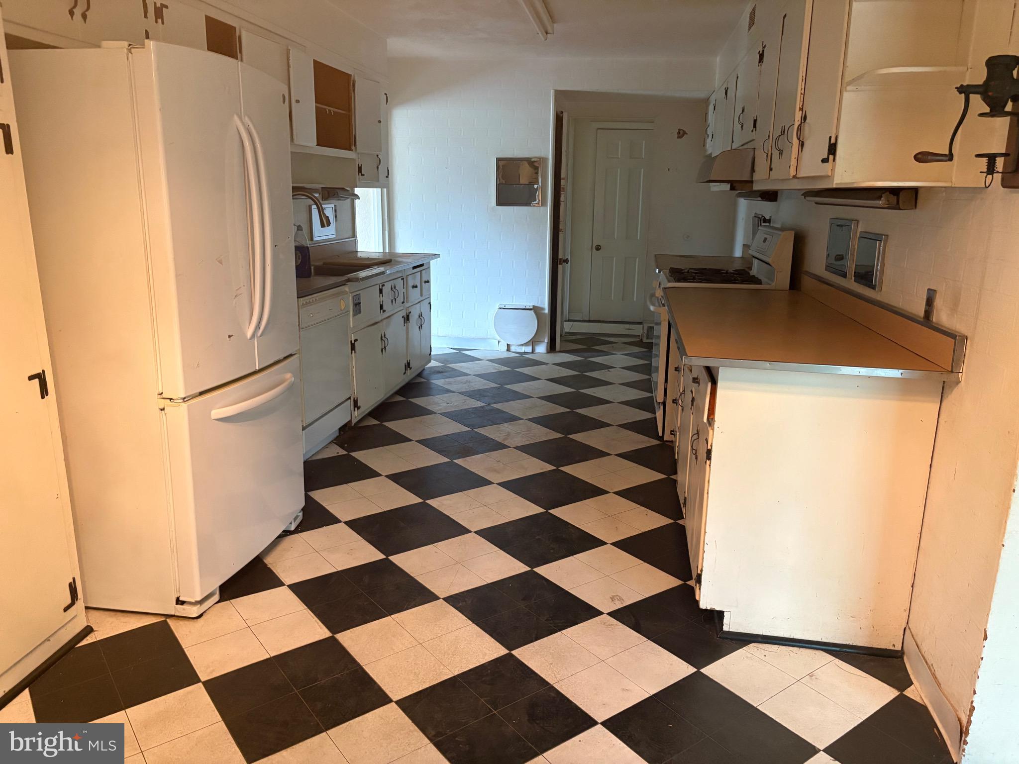 1041 Kipling Road Jenkintown, PA 19046 - Photo 3 of 23 a kitchen with a checkered floor and white cabinets