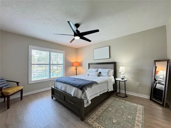 a bedroom with a bed a chandelier and a window