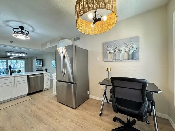 a kitchen with stainless steel appliances granite countertop a refrigerator a stove and a wooden floor
