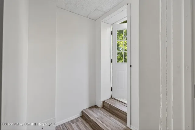 a view of a room with wooden floor and small window