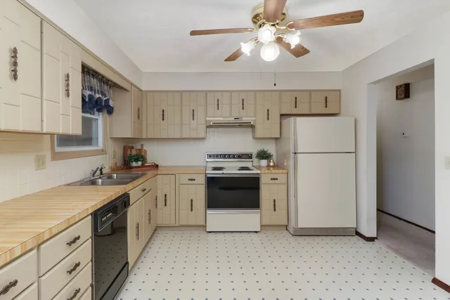 a kitchen with stainless steel appliances a refrigerator sink and white cabinets