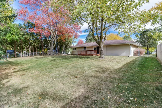 a backyard of a house with large trees and parked
