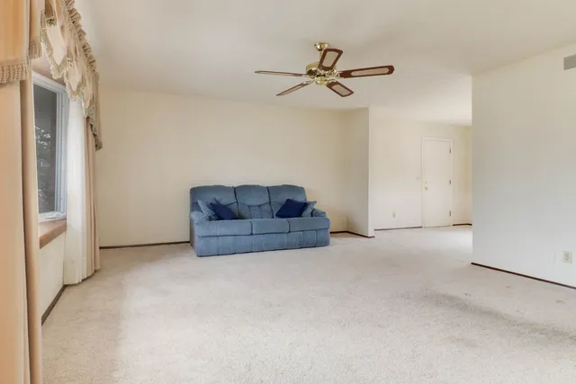 a living room with furniture and a ceiling fan