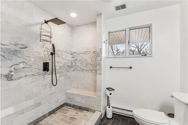 a bathroom with a shower a toilet and a shower