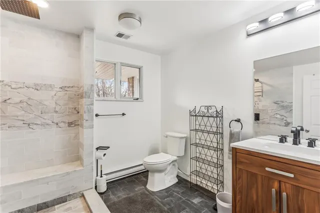 a bathroom with a sink a toilet and shower