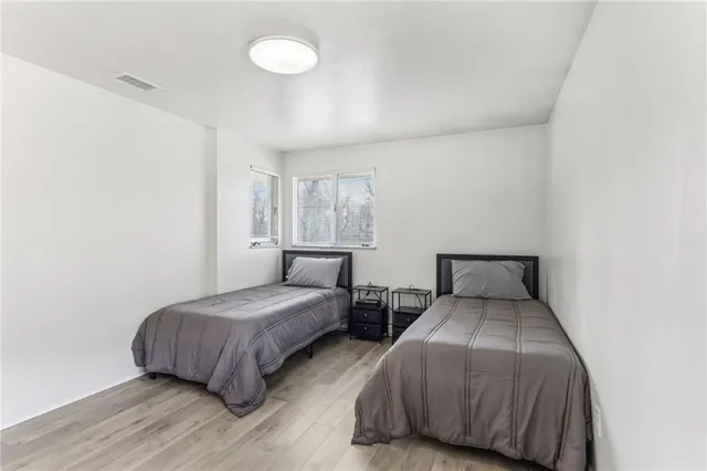 a bedroom with two beds and painting on the wall