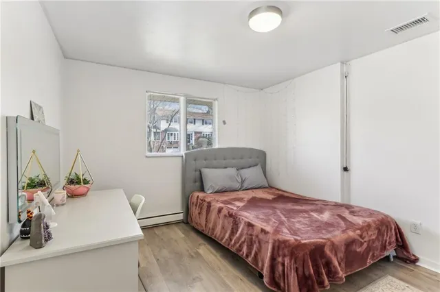 a bedroom with a bed and painting on the wall