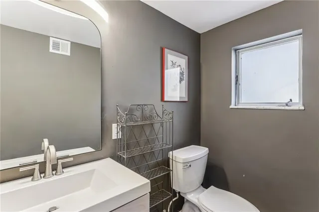 a bathroom with a toilet a sink and mirror