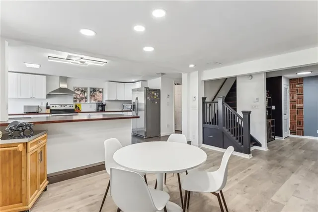 a kitchen with stainless steel appliances kitchen island granite countertop a refrigerator a stove a sink dishwasher with a dining table and chairs