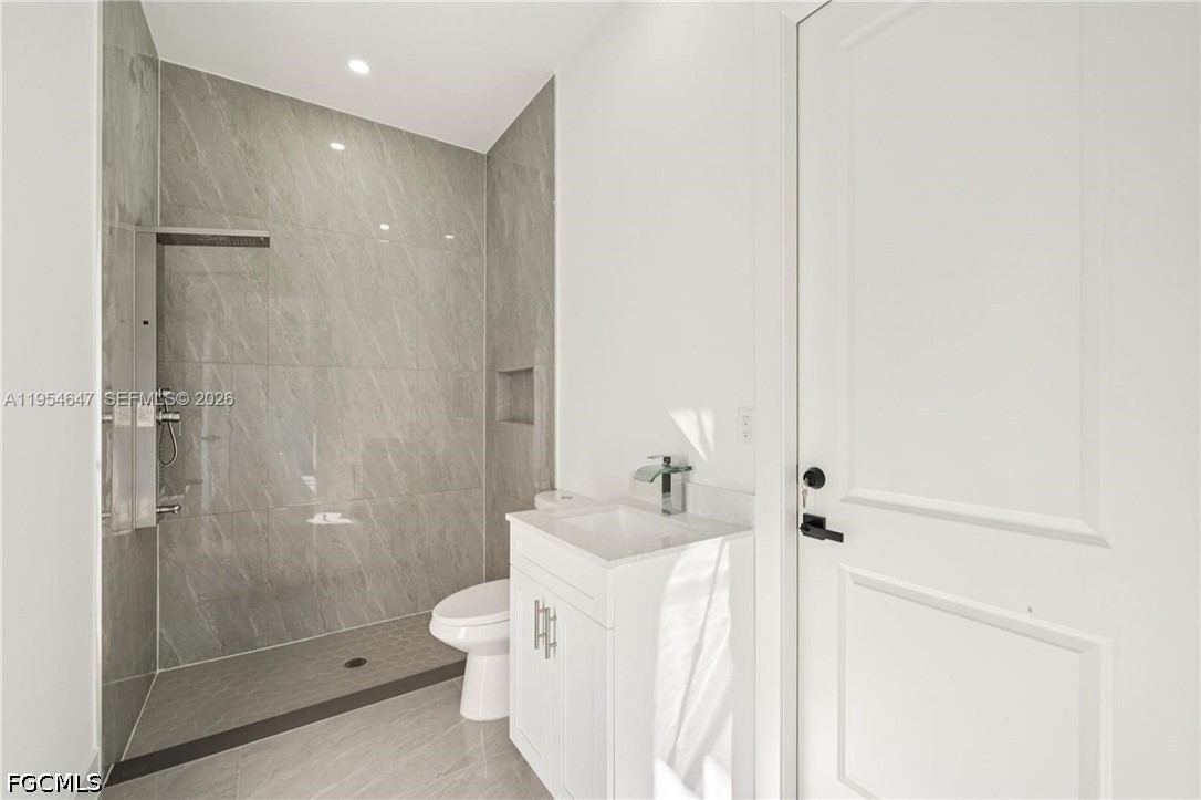 4402 East 19th Street Lehigh Acres, FL 33972 - Photo 19 of 27 a bathroom with a bathtub shower sink mirror and toilet
