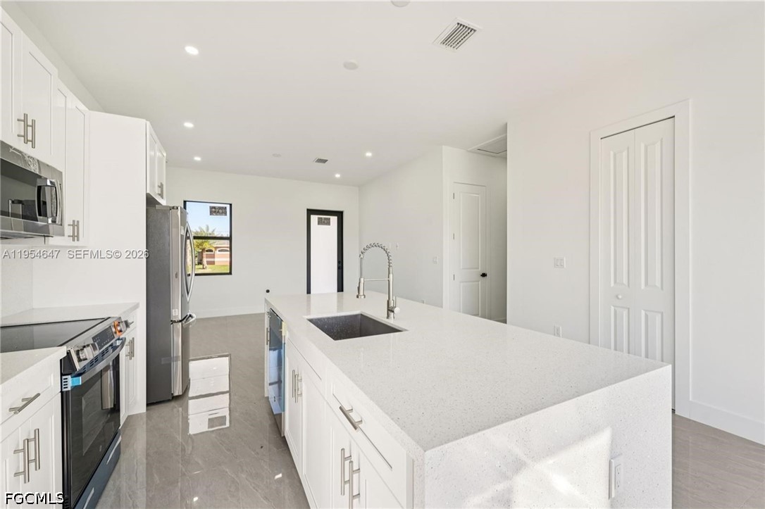 4402 East 19th Street Lehigh Acres, FL 33972 - Photo 6 of 27 a kitchen with a sink stove and a refrigerator