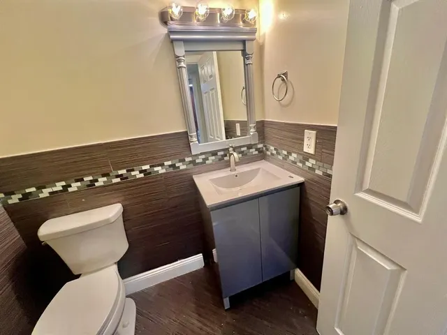 a bathroom with a sink vanity mirror and toilet
