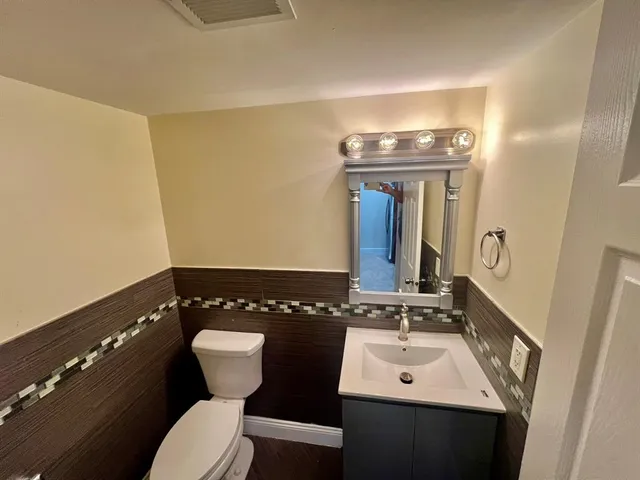 a bathroom with a toilet a sink and mirror