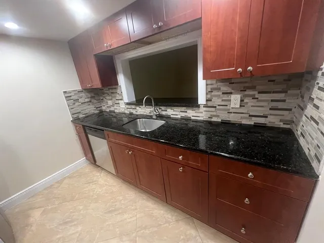 a kitchen with sink a microwave and cabinets