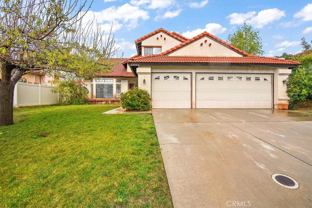 a view of a house with a backyard and a garage