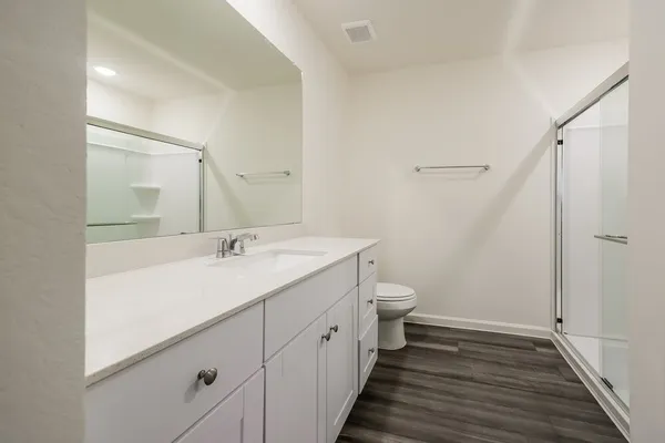 a spacious bathroom with a double vanity sink toilet and shower