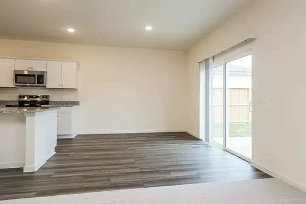a view of kitchen with wooden floor electronic appliances and window