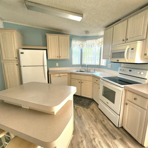 a kitchen with a table chairs refrigerator and cabinets