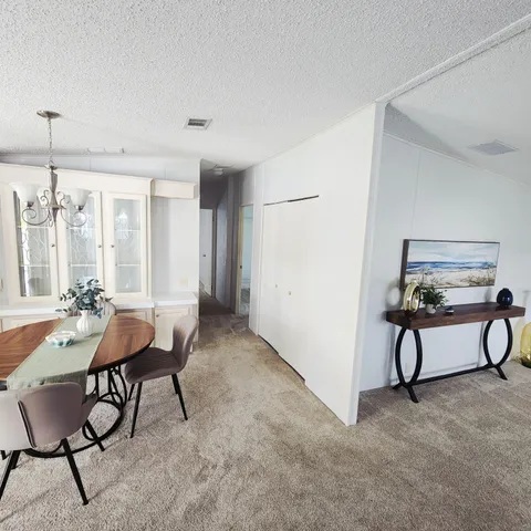 a bed sitting in a bedroom next to a window and a chandelier