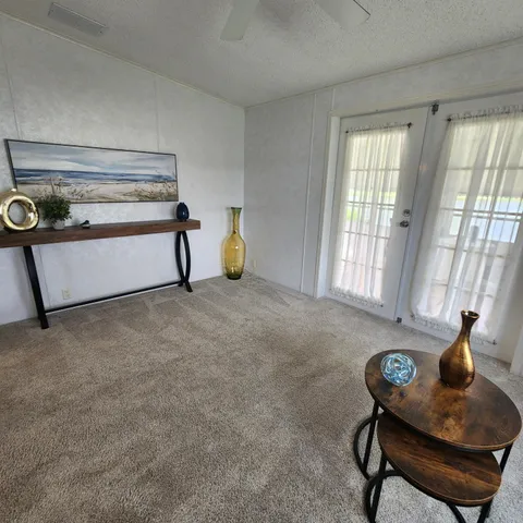 a living room with a black white checkered floor with a dining table and chairs