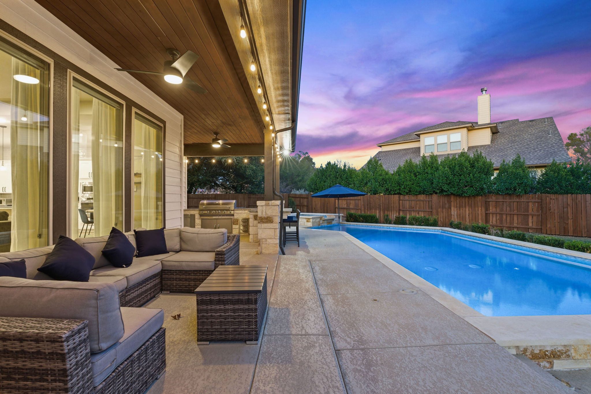 512 Choke Canyon Lane Georgetown, TX 78628 - Photo 2 of 37 Pool at dusk with a fenced backyard, an outdoor kitchen, a patio, outdoor lounge area, and a pool with connected hot tub
