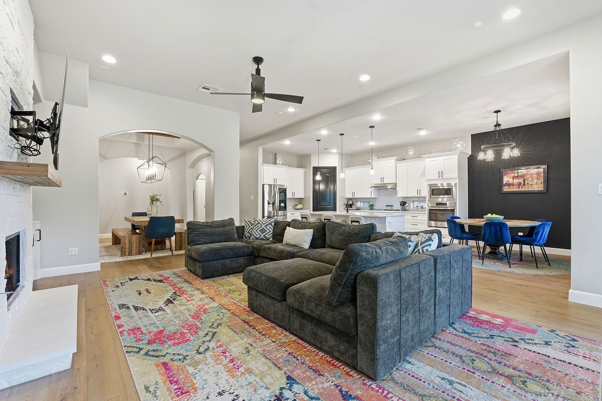 512 Choke Canyon Lane Georgetown, TX 78628 - Photo 3 of 37 Living area with a chandelier, arched walkways, a fireplace, light wood-style floors, and recessed lighting