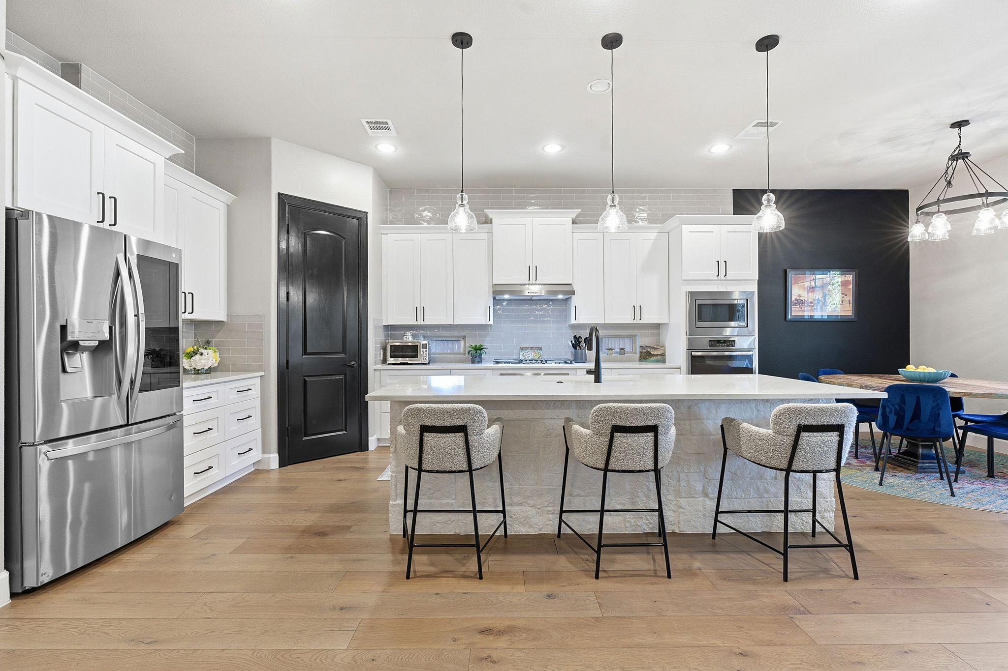 512 Choke Canyon Lane Georgetown, TX 78628 - Photo 9 of 37 Kitchen with appliances with stainless steel finishes, hanging light fixtures, white cabinets, a kitchen breakfast bar, and recessed lighting