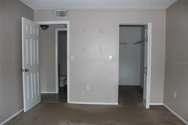 an empty room with closet and a bathroom