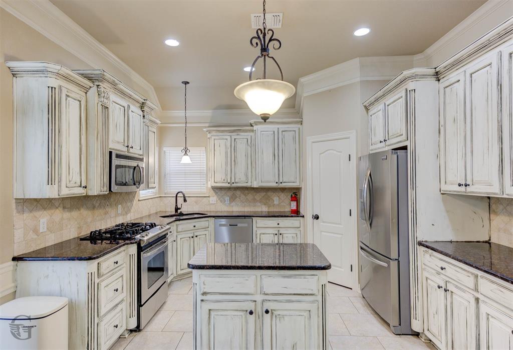 830 Entrada Bossier City, LA 71111 - Photo 7 of 25 a kitchen with granite countertop a sink stainless steel appliances and cabinets