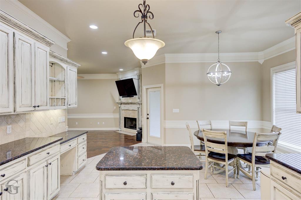 830 Entrada Bossier City, LA 71111 - Photo 8 of 25 a kitchen with granite countertop wooden cabinets and a chandelier
