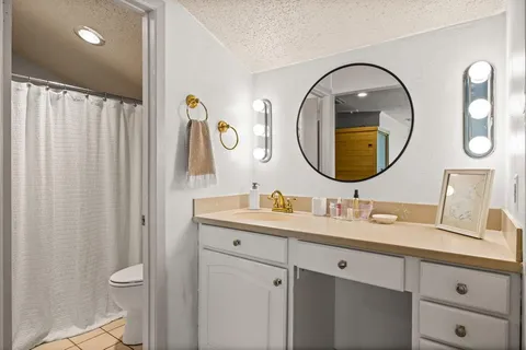 a bathroom with a granite countertop sink and a mirror