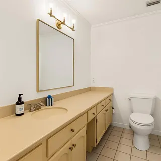 a bathroom with a sink a toilet and a mirror
