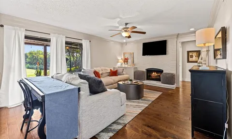 a living room with furniture a fireplace and a flat screen tv