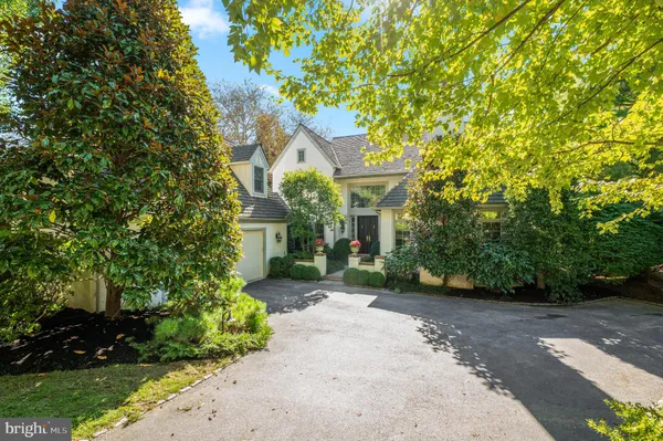 a front view of a house with a yard and green space