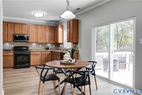 a kitchen with a dining table chairs and large windows