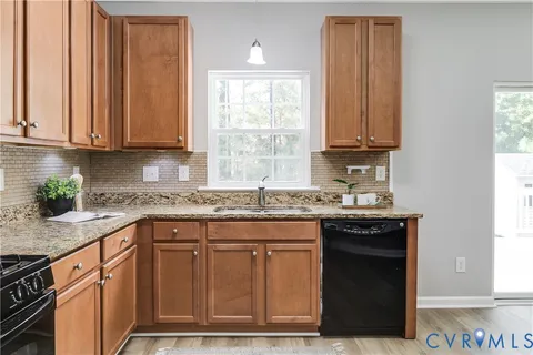 a kitchen with granite countertop a sink and a stove