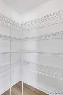 a view of an empty room with closet and windows