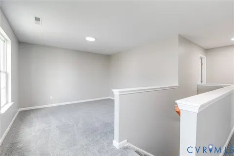 an empty room with wooden cabinet and windows